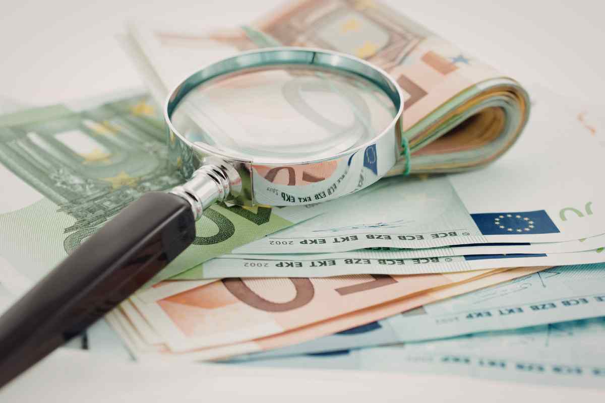 banconote e una lente di ingrandimento