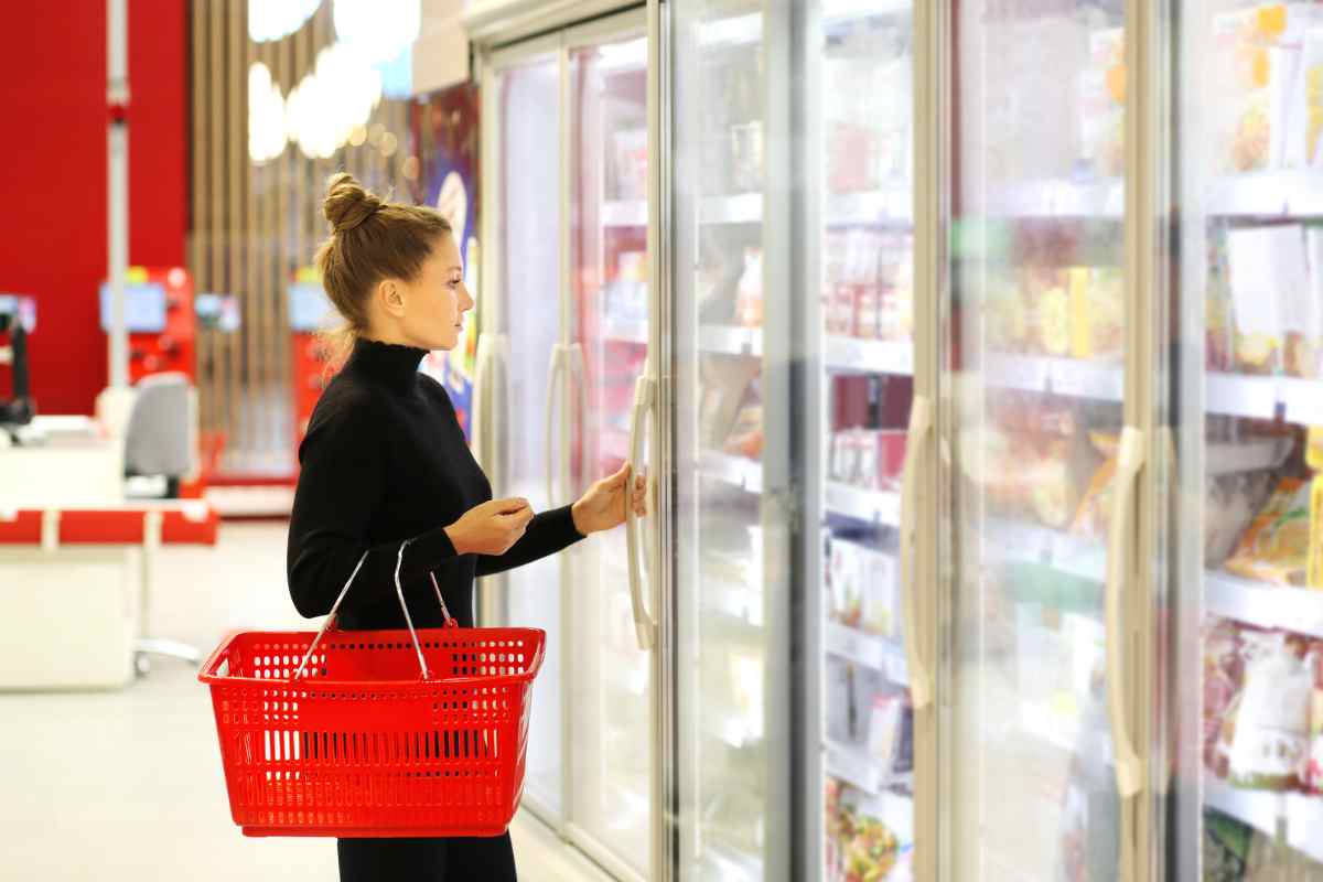donna davanti al reparto surgelati di un supermercato