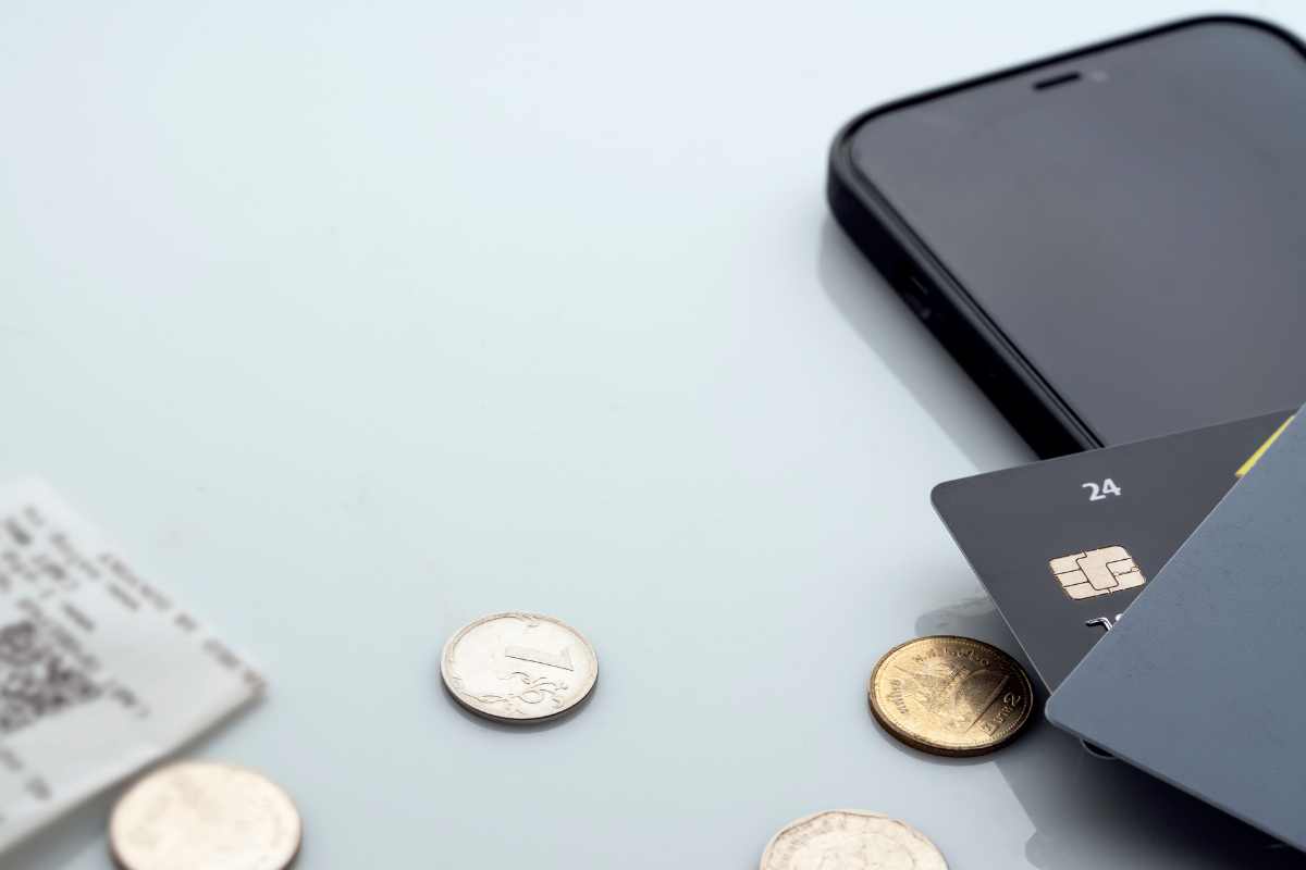 carta bancomat, smartphone e monete