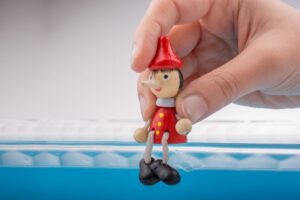 mano che mantiene un pupazzetto in legno di pinocchi