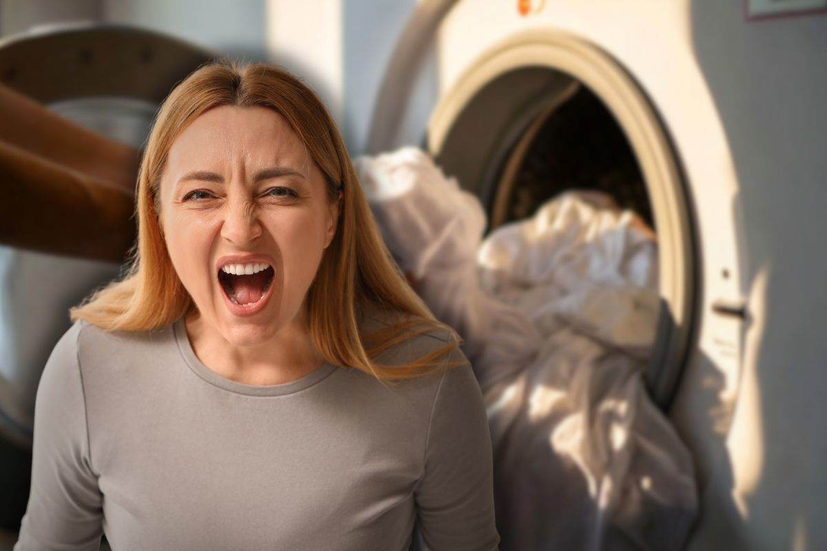 donna con bucato in lavatrice e un'altra che urla
