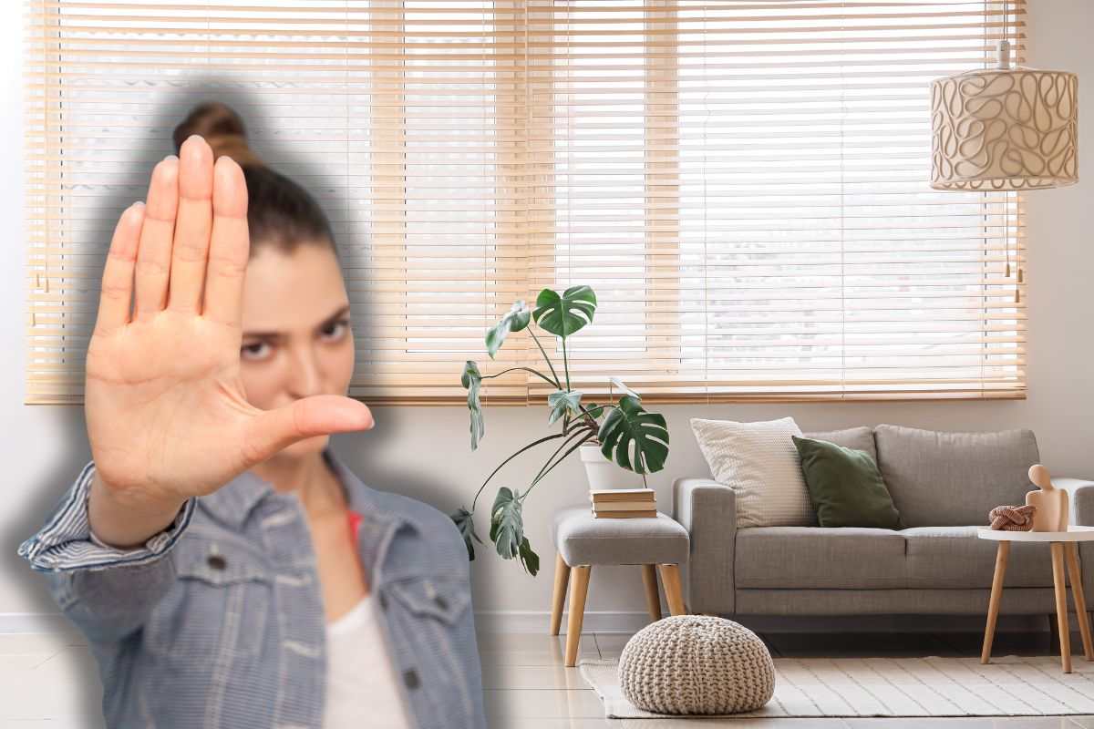 divano contro parete e donna che fa stop con le mani