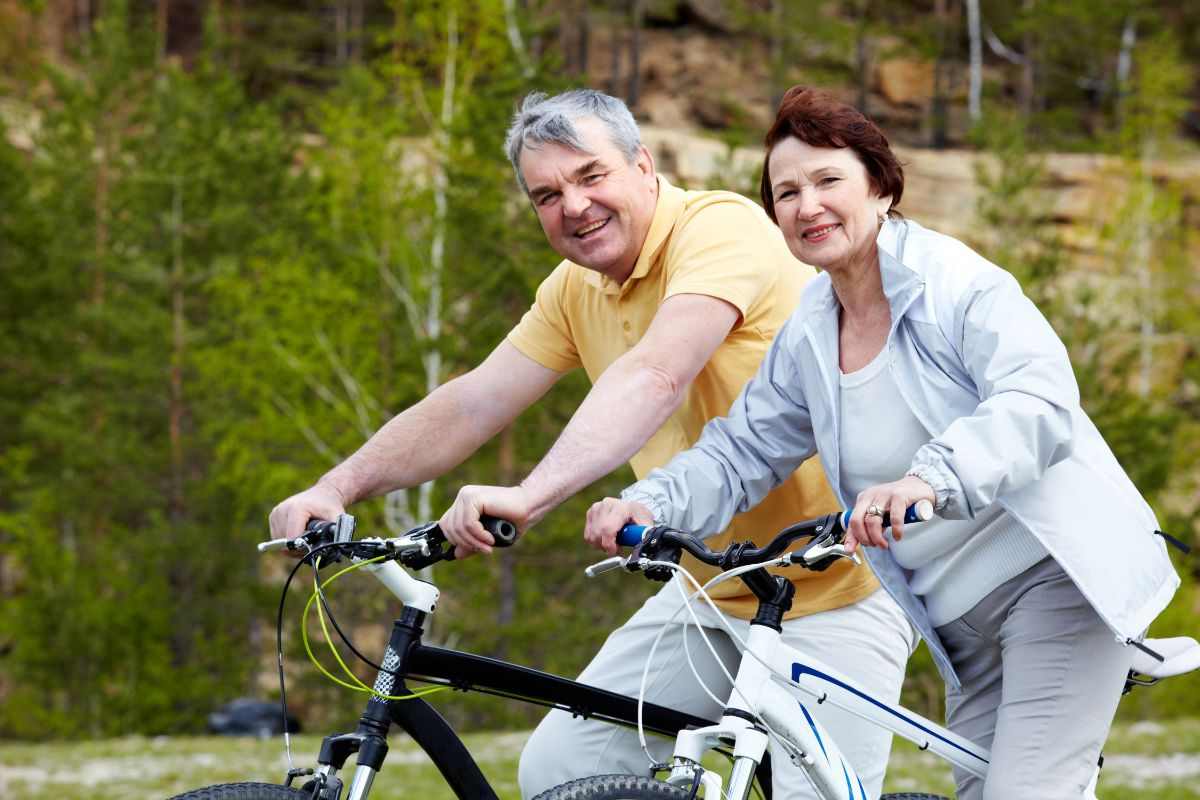 coppia di persone mature che vanno in bicicletta