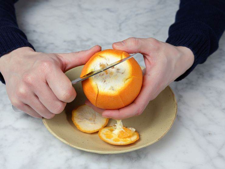 persona che sbuccia arancia